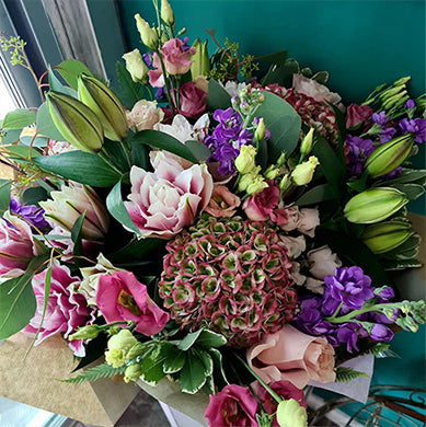 Richly coloured bouquet of pink lilies, purple stocks and hydrangea, freshly tied at The Petal Boutique workbench