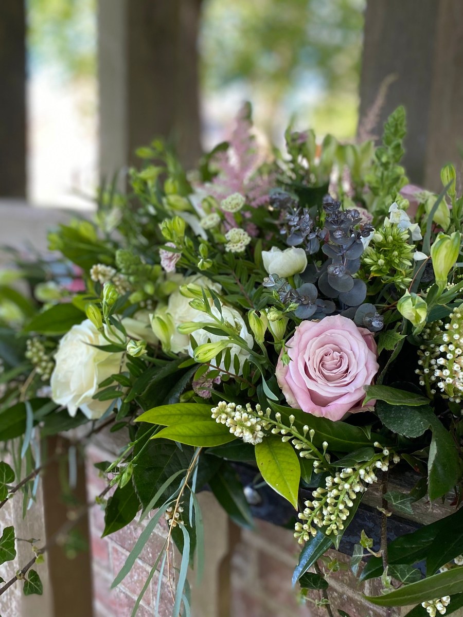 Soft funeral tribute of blush pink and white roses with eucalyptus, arranged by The Petal Boutique florists in Winchester